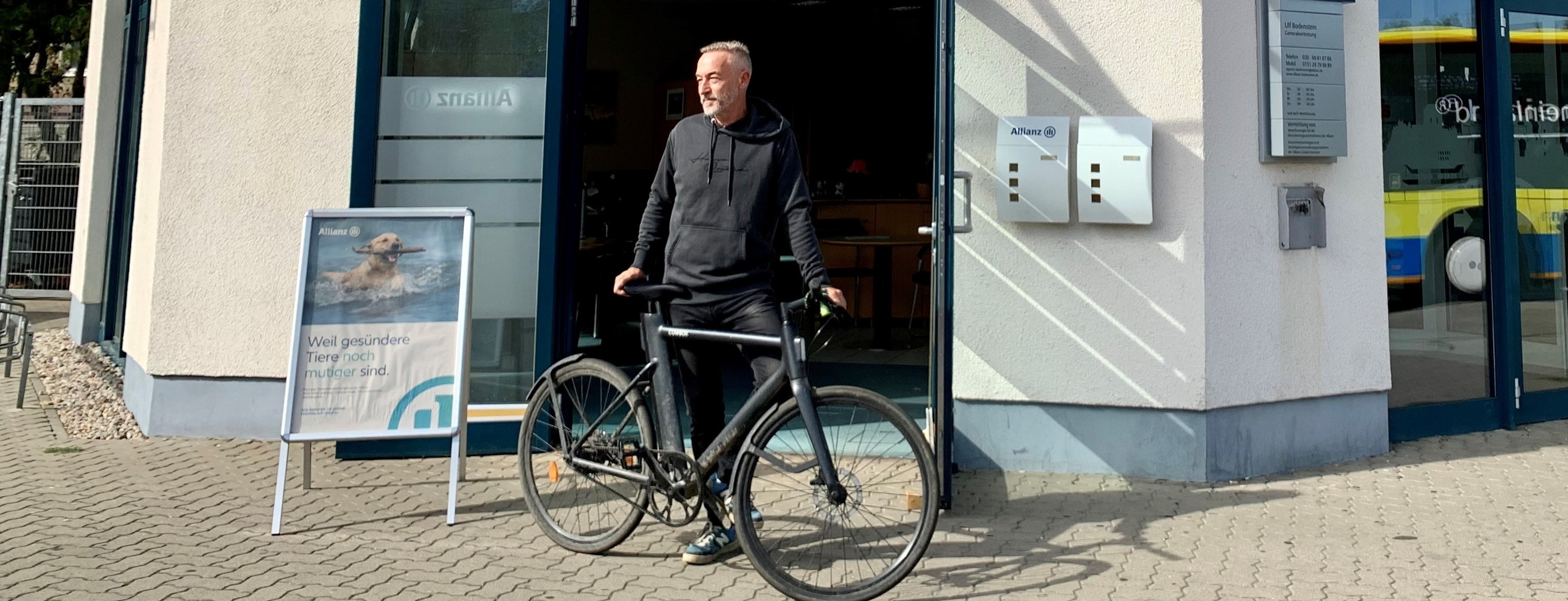 Allianz Versicherung Ulf Bodenstein Berlin - Ulf Bodenstein steht mit Fahrrad vor der Agentur