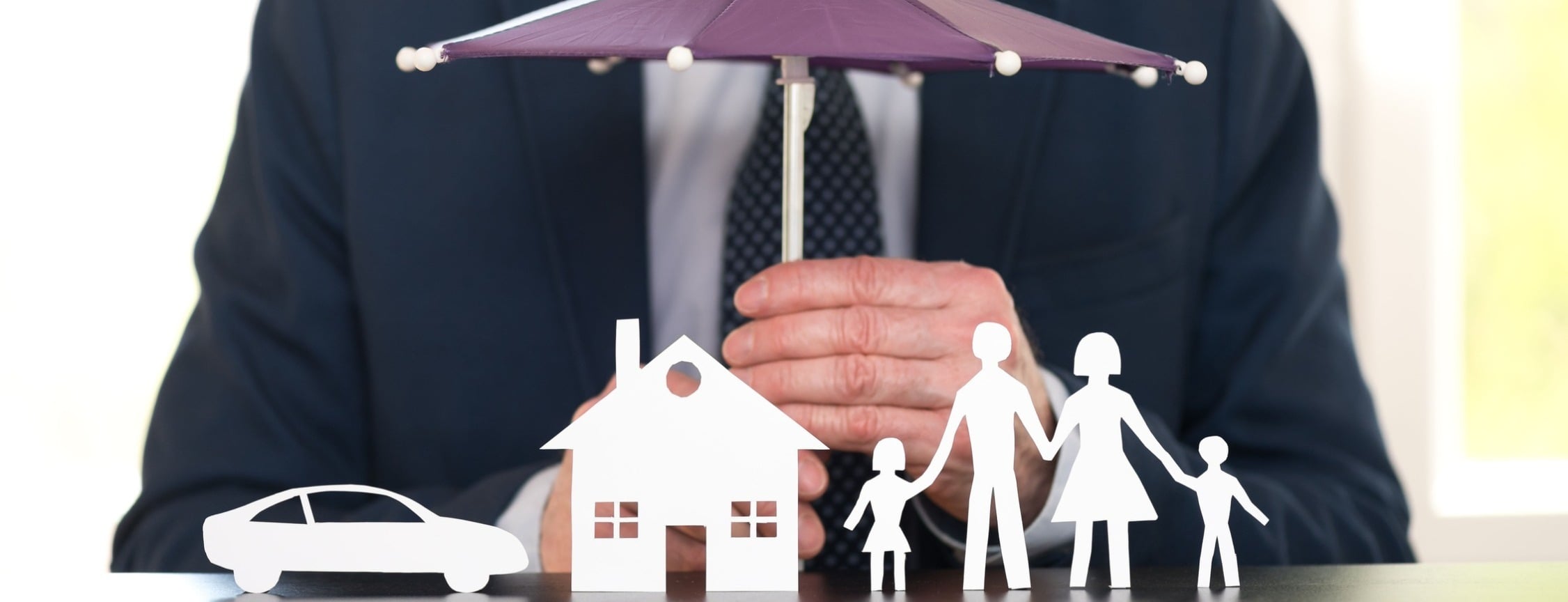 Allianz Versicherung Julia Schnell Berlin - Mann hält über Schutzschirm Familie und Eigentum